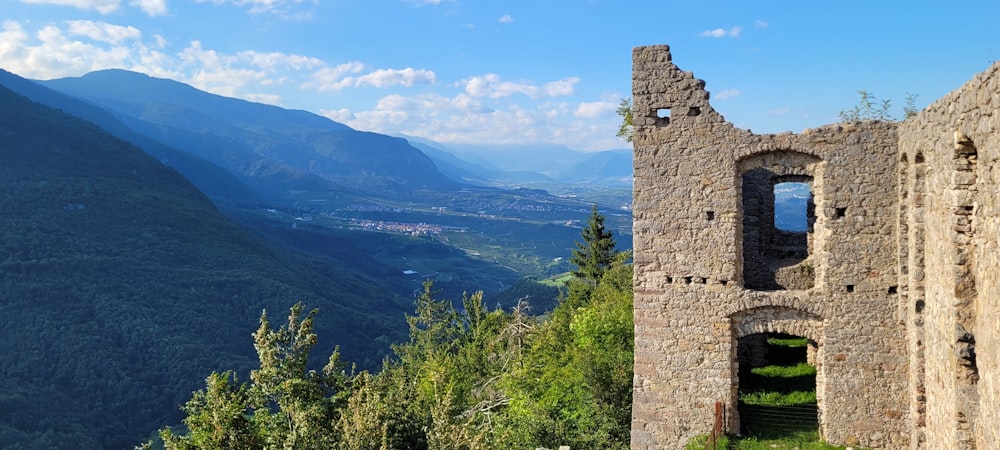 a stone tower sitting on top of a lush green hillside