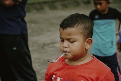 a young boy with a spoon in his mouth