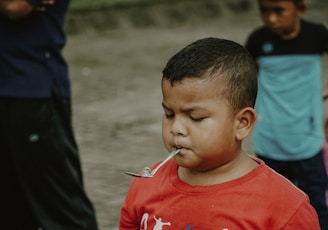 a young boy with a spoon in his mouth