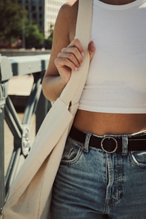 a woman wearing a white top and jeans
