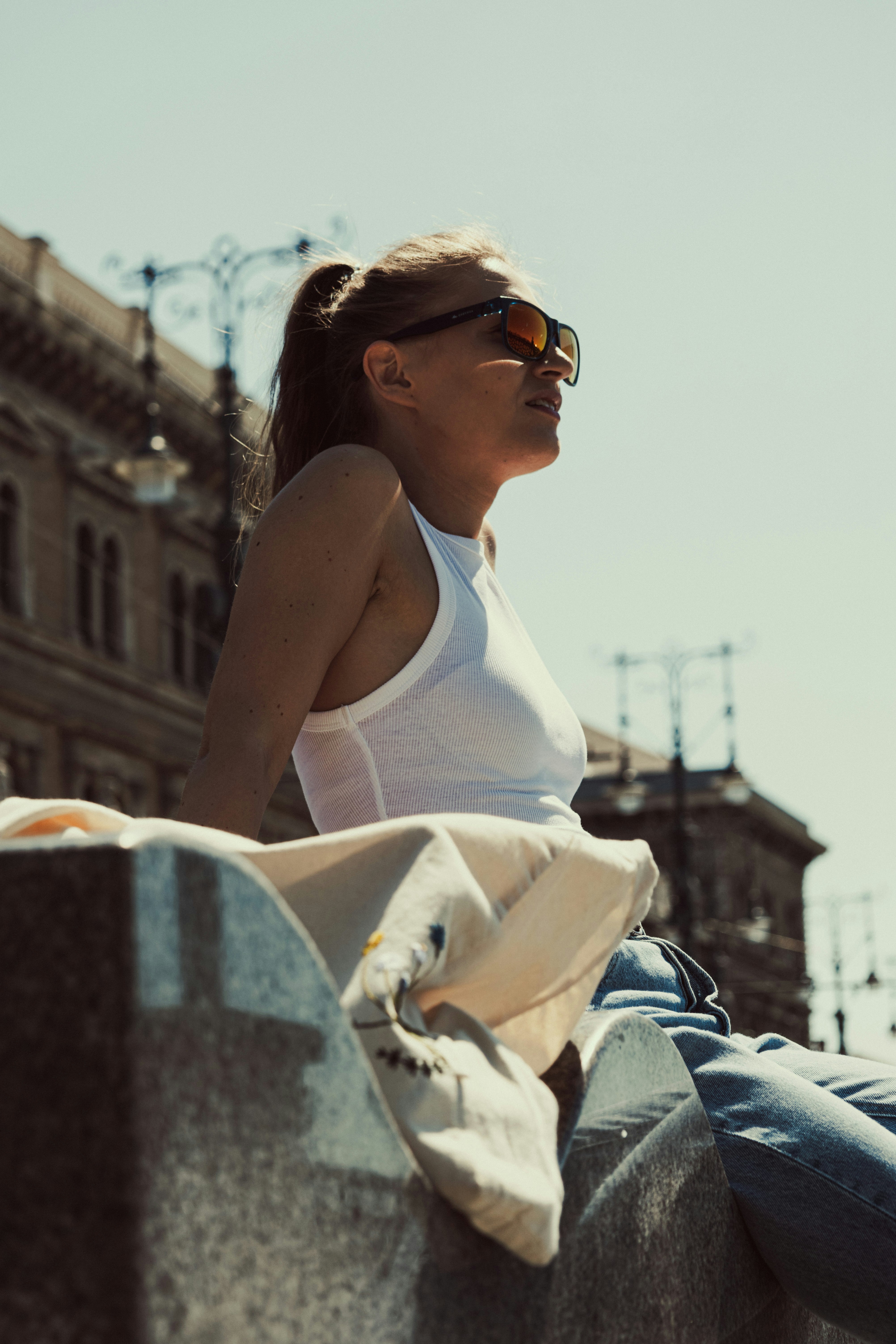 a woman sitting on top of a cement wall