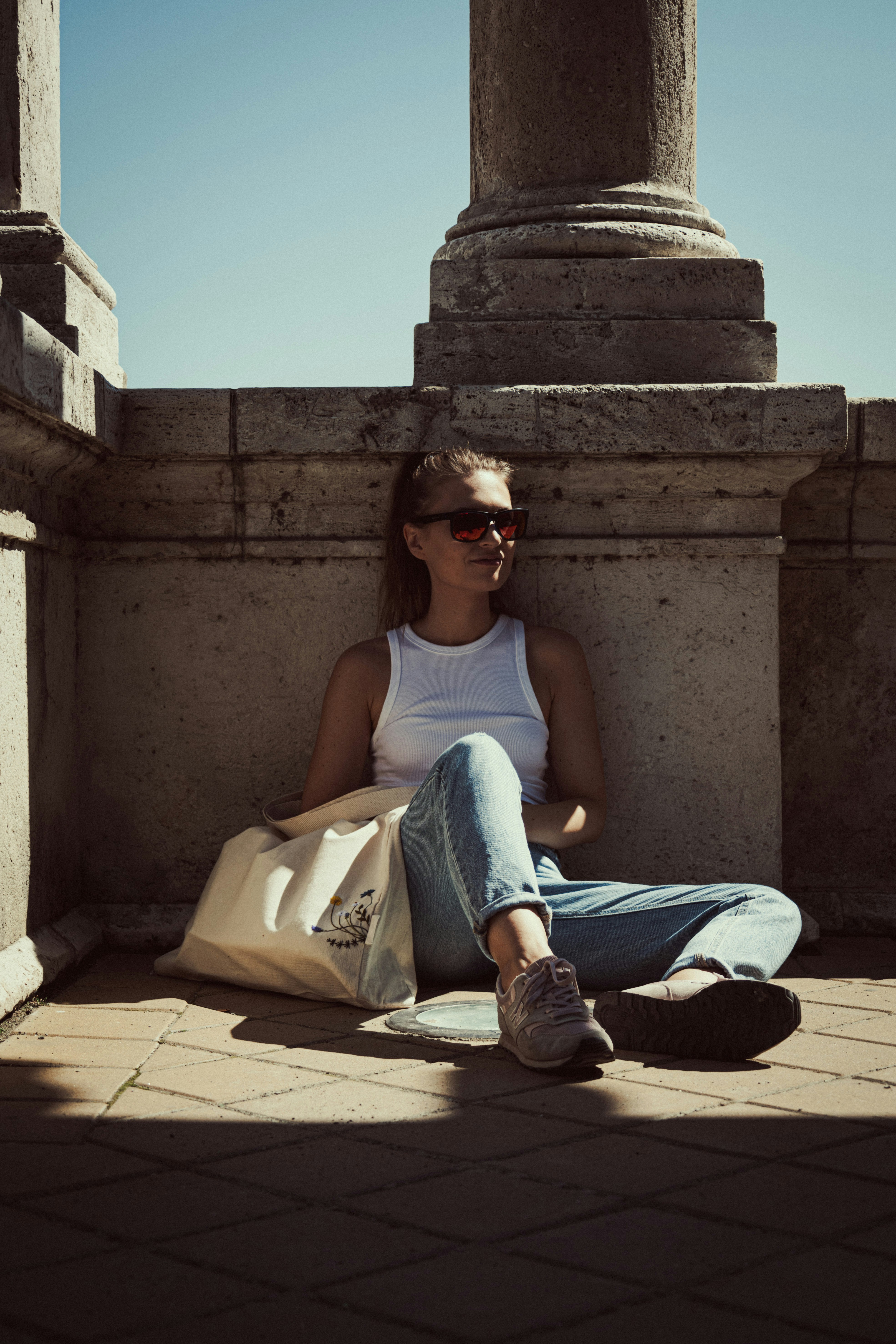 a woman sitting on the ground with a bag