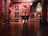 An art gallery interior with several large, classical paintings displayed on deep red walls. The floor is made of polished wood with decorative patterns. Ornate, classical-style furniture and vases are placed around the room. The lighting is soft, highlighting the artwork.