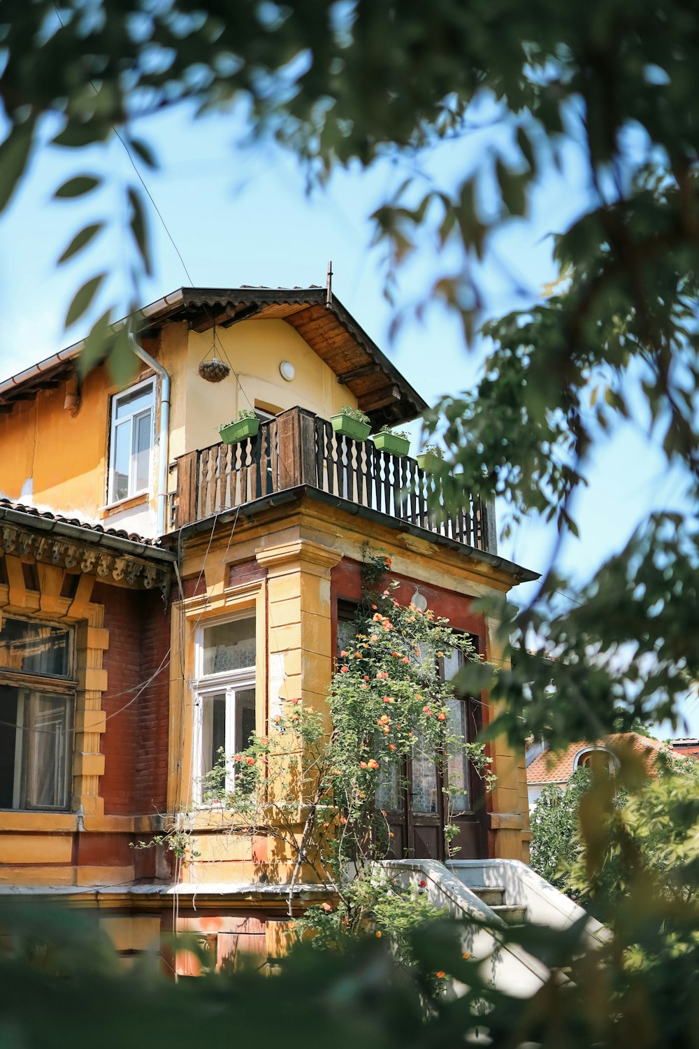 a yellow house with a balcony and balcony railing