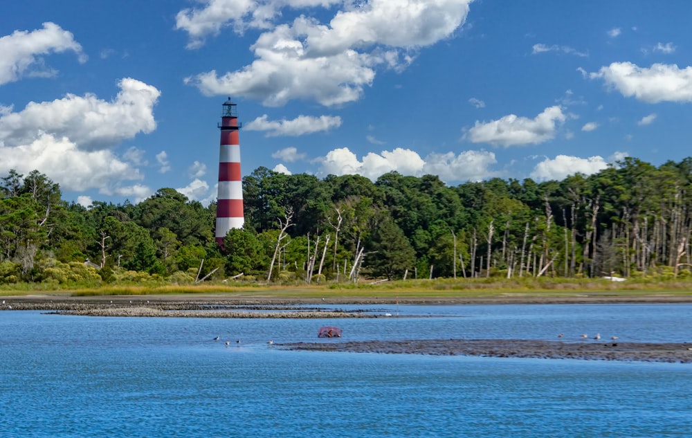 a large body of water with a light house in the background