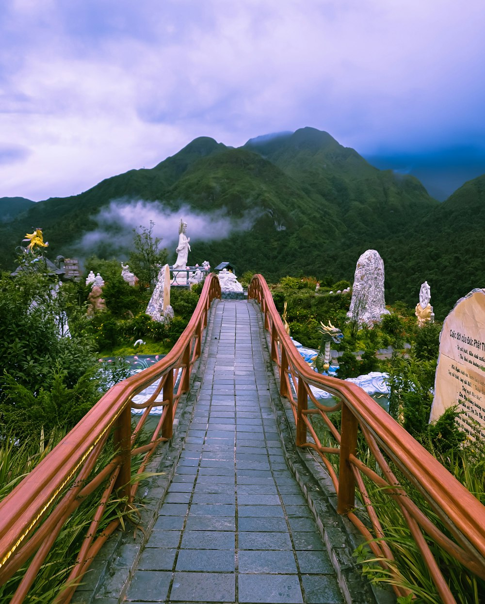 a wooden walkway leading to a cemetery with a mountain in the background