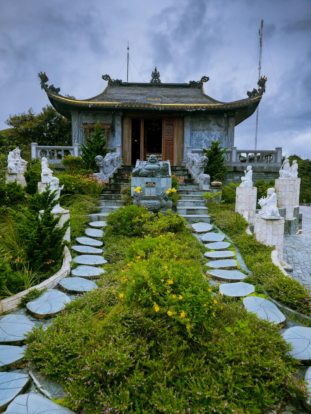 a stone path leading to a building with a pagoda in the background
