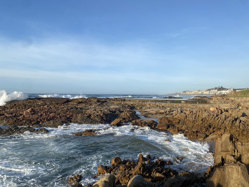 a rocky shore with waves crashing against the rocks