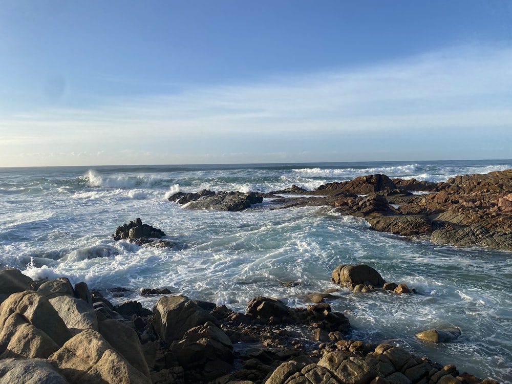 a rocky shore with waves crashing against the rocks