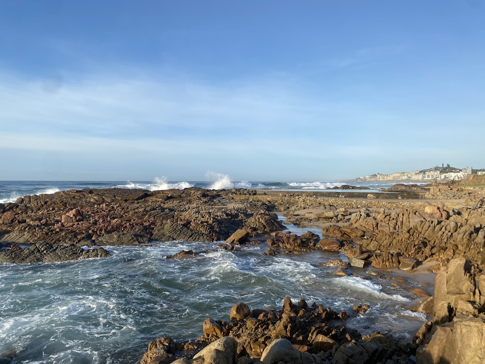 a rocky shore with waves crashing against the rocks