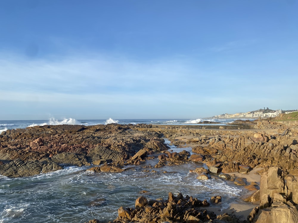 a rocky shore with a body of water