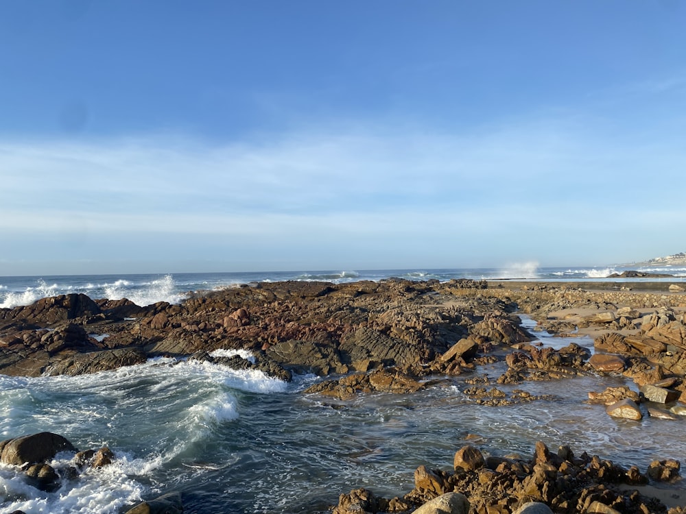 a rocky shore with waves crashing against the rocks