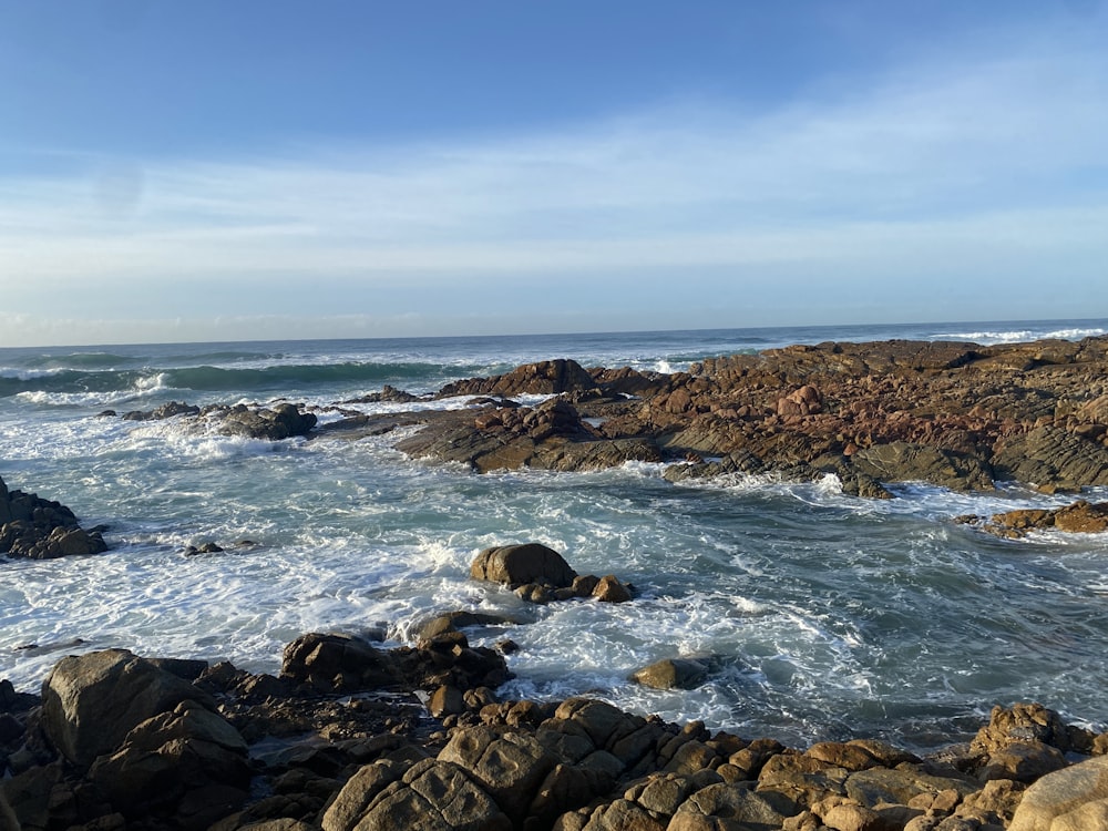 a view of the ocean from a rocky shore