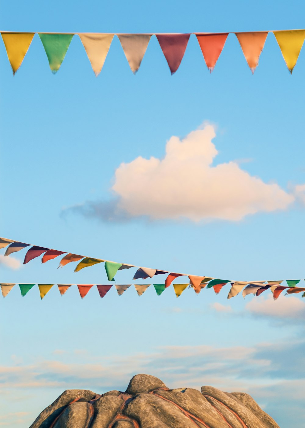 colorful flags are hanging over a rock formation