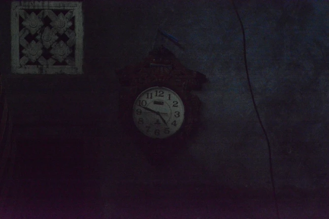 A dimly lit photo of a vintage clock showing a forgotten time.