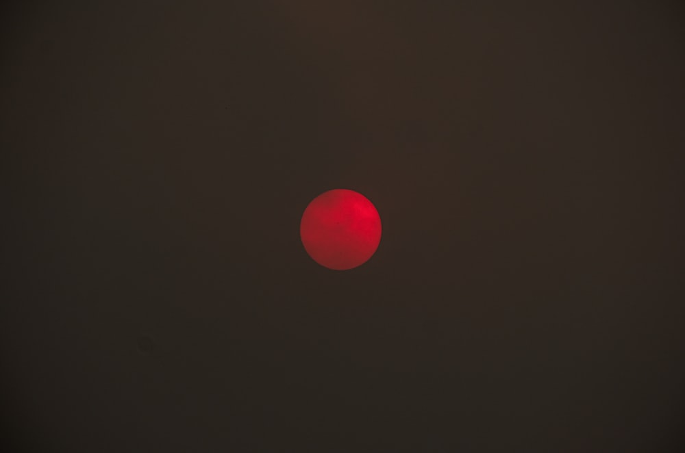 Une lumière rouge brille dans le ciel sombre