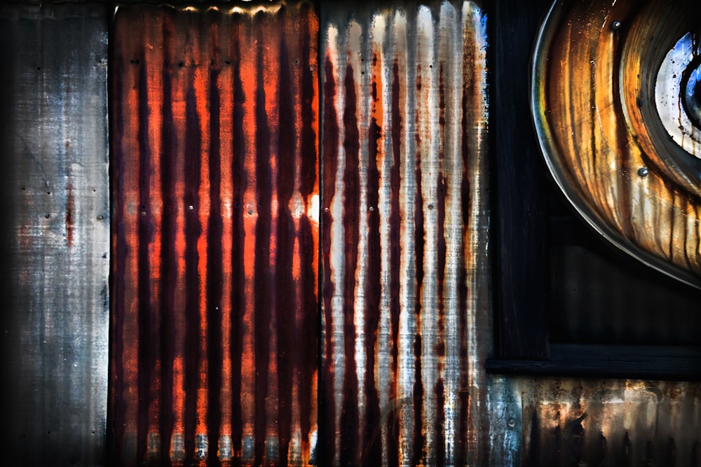 a rusted metal wall with a round window