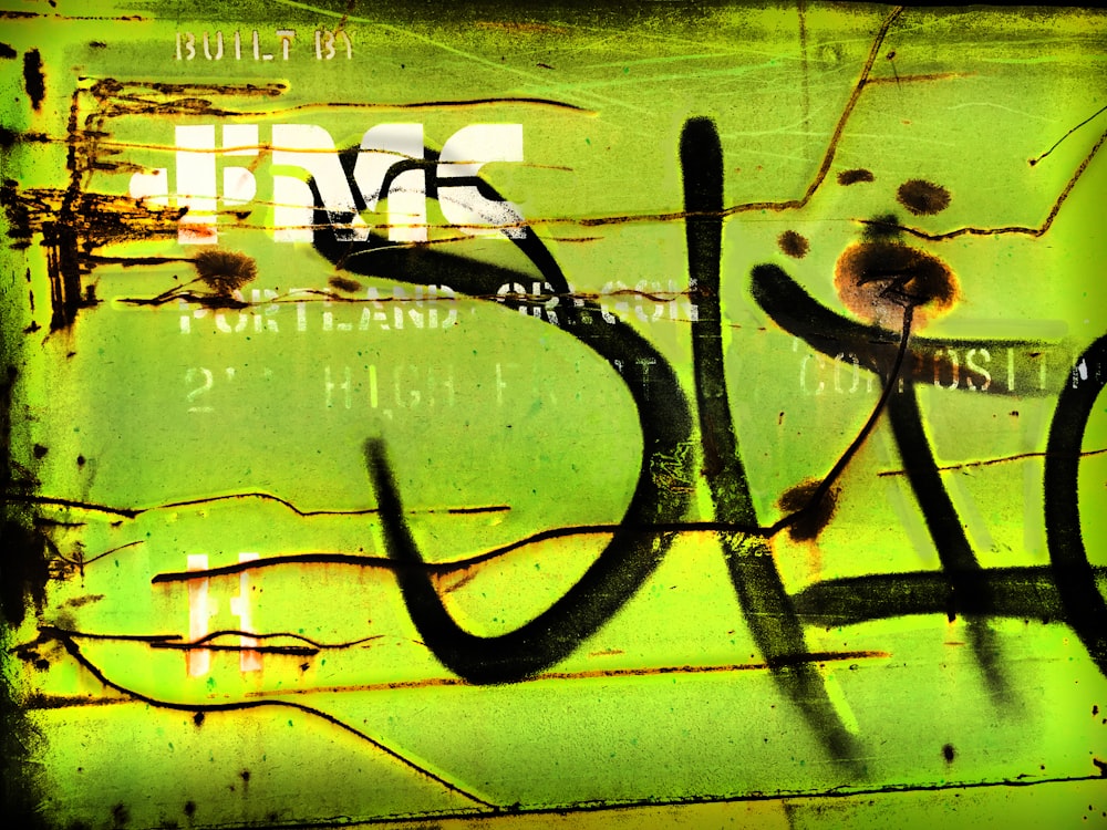 graffiti on the side of a green wall