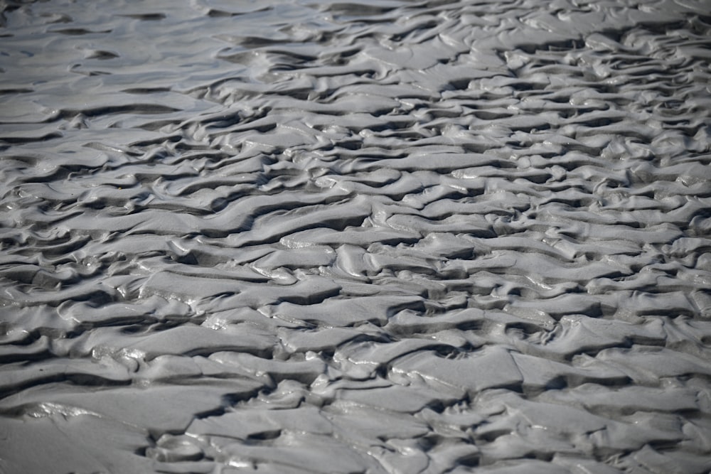 a black and white photo of sand and water