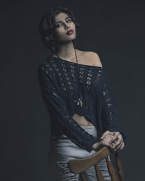 A casual-chic outfit featuring a lightweight knit sweater paired with sleek trousers on a wooden chair.