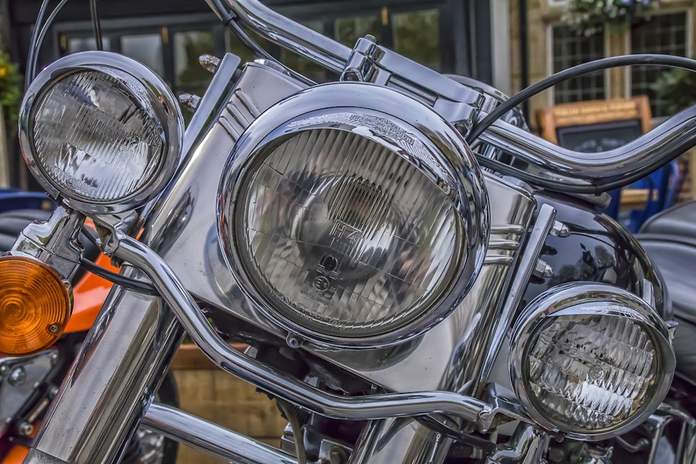 a close up of a motorcycle headlight with a building in the background