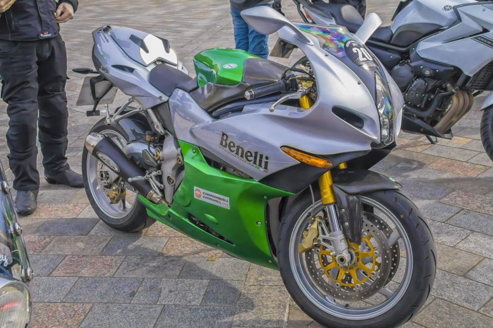 a green and silver motorcycle parked next to other motorcycles