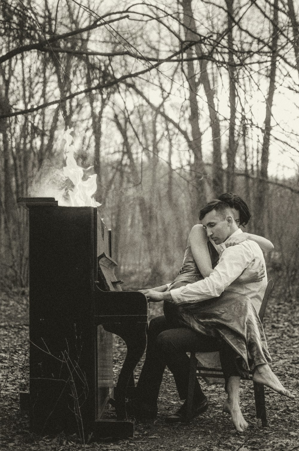 a man and woman sitting on a bench next to a piano