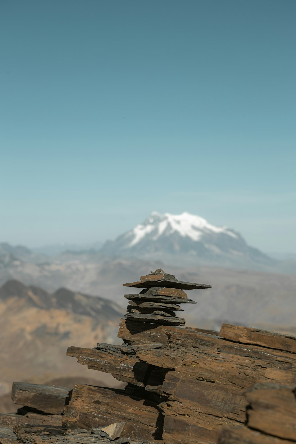 a stack of rocks with a mountain in the background