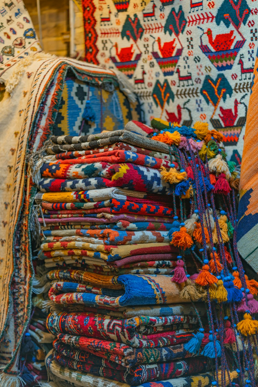 a pile of colorful fabrics on display in a store