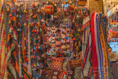 Colorful women's textiles displayed at a bustling market stall, reflecting cultural craftsmanship.