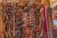 A vibrant display of colorful batik sarongs hanging in an open-air market setting.