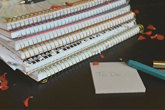 A stack of well-worn movie tickets and handwritten notes scattered on a dark desk.