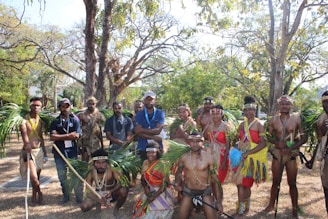 A community group gathered outdoors during a cultural event in a natural setting.