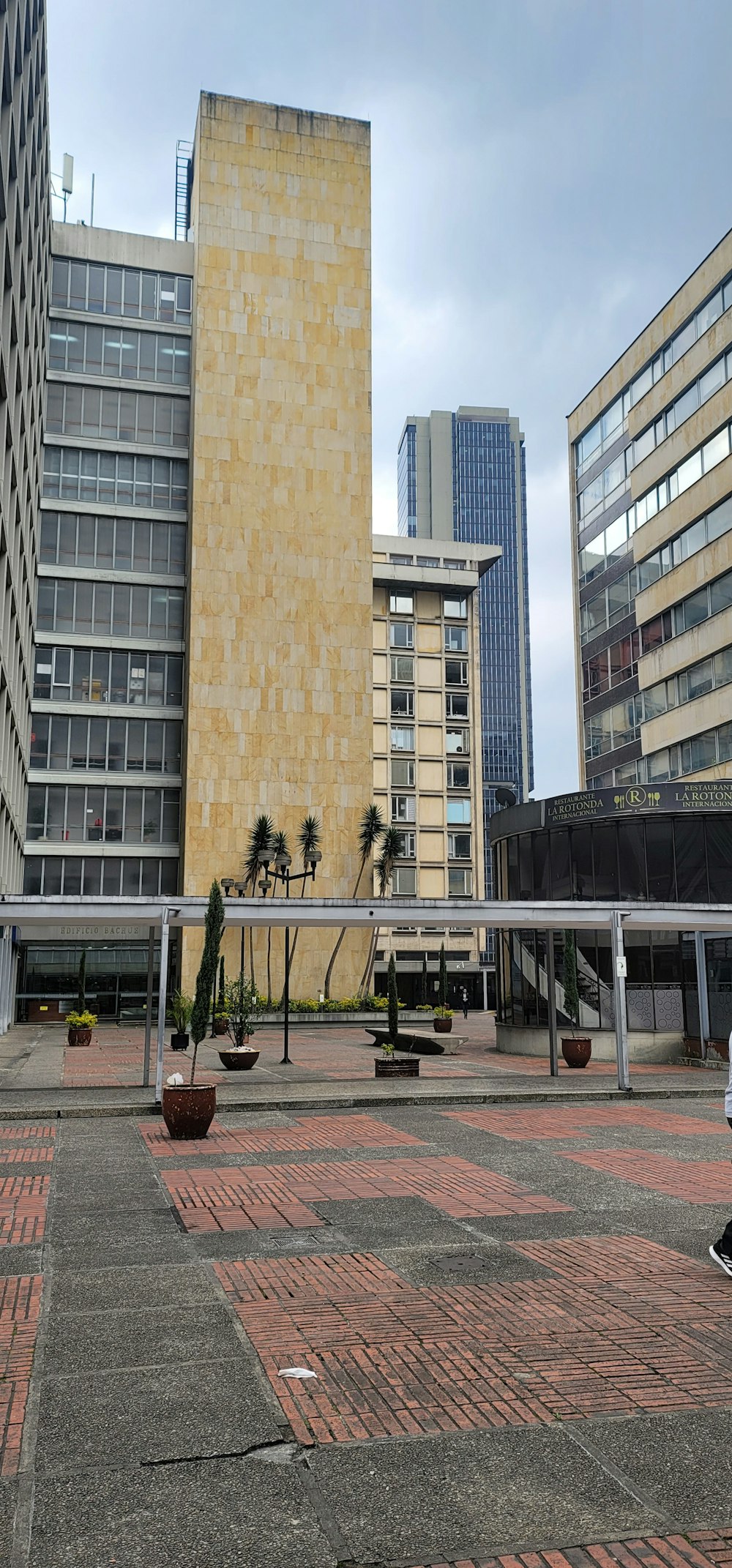 a person walking down a walkway in front of some buildings