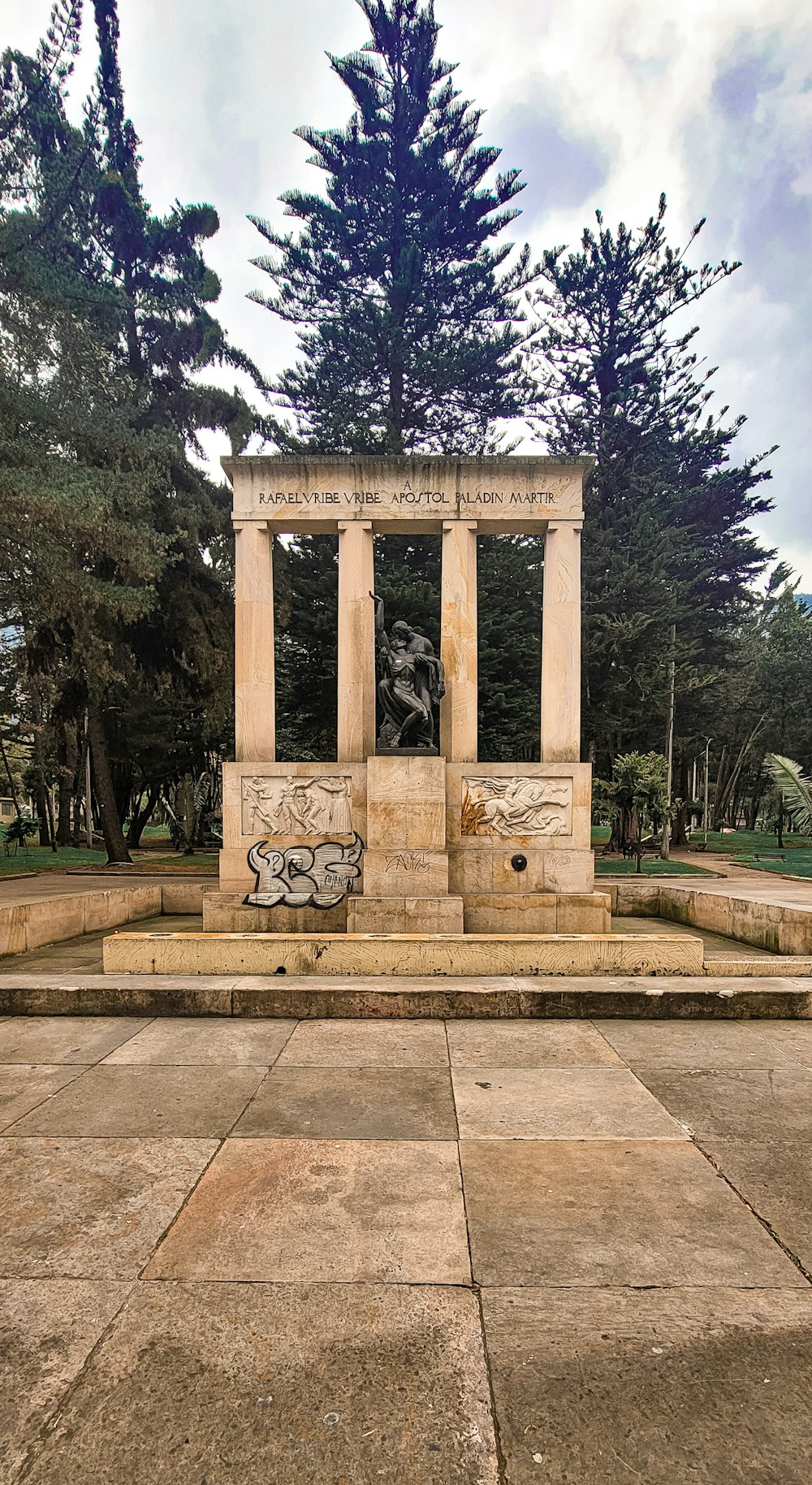 a monument in a park with trees in the background