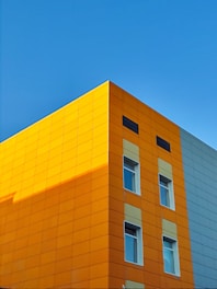 Close-up of a freshly renovated building facade with clean lines and warm orange accents.