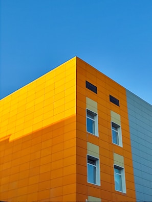 Picture of a modern office building with blue and orange branding visible on the facade.