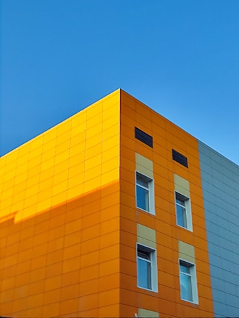 Exterior view of a contemporary building with vibrant orange highlights.