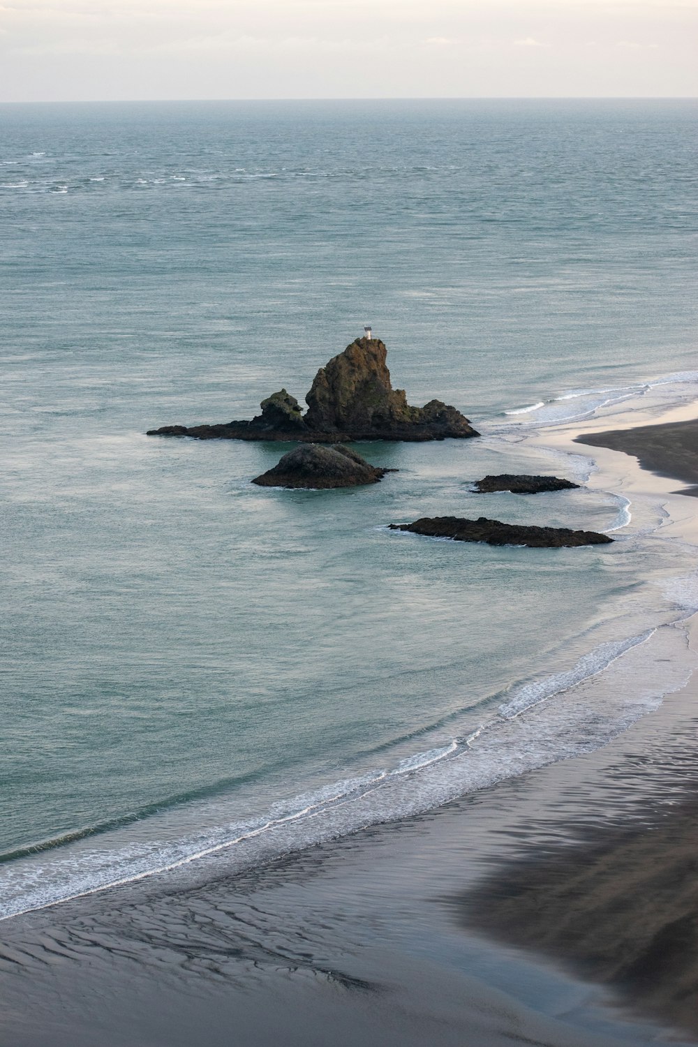 una gran masa de agua sentada junto a una playa de arena