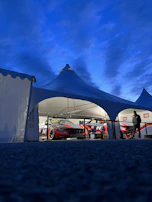 Canopy tent adorned with custom graphics at a sunny racing event.