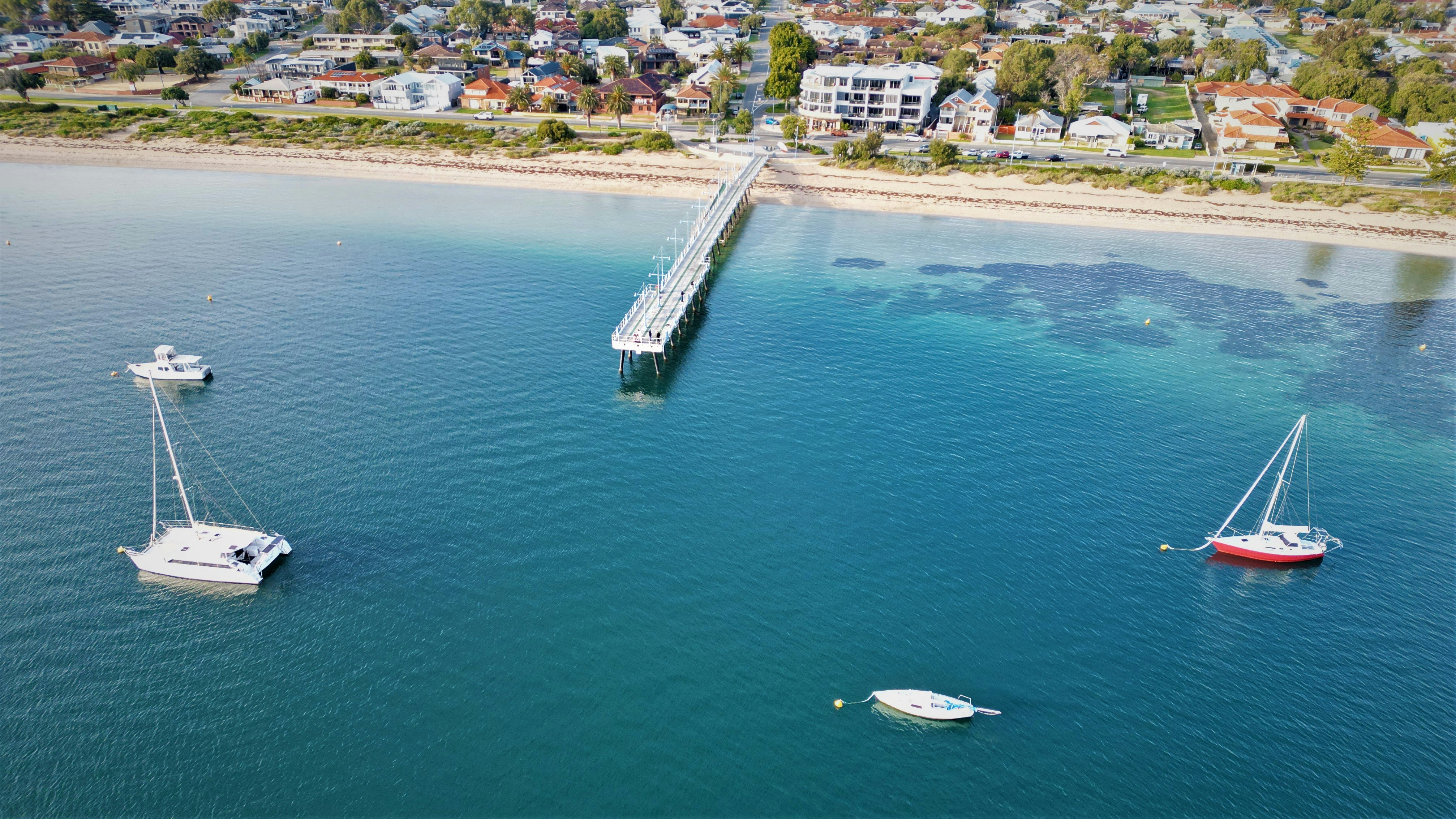 A couple of boats floating on top of a body of water photo – Free ...