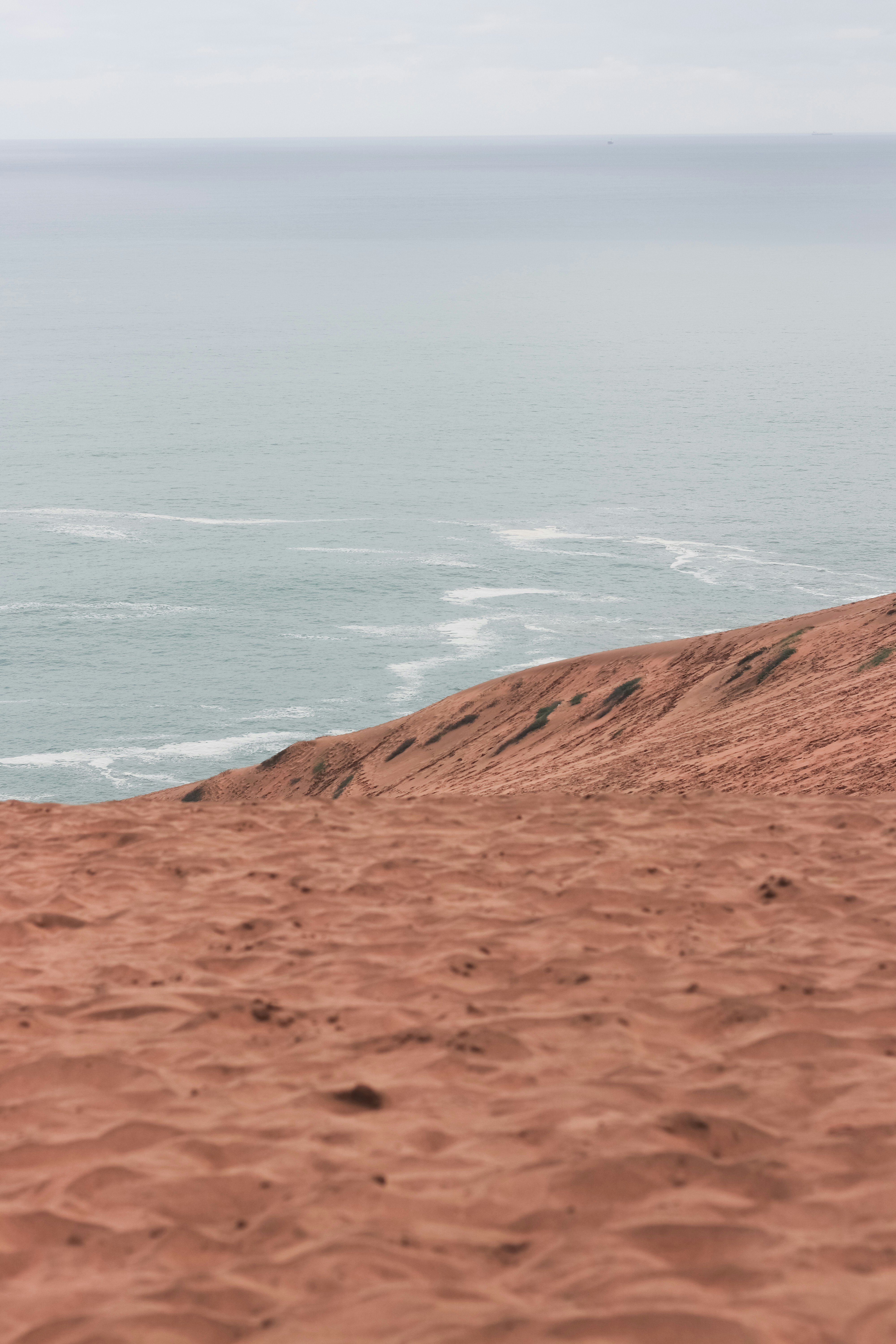 a man riding a surfboard on top of a sandy beach