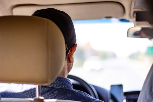 a man sitting in a car looking out the window