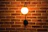 Close-up of a brass wall sconce illuminating a textured wall with warm light.