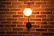 Close-up of a brass wall sconce illuminating a textured wall with warm light.