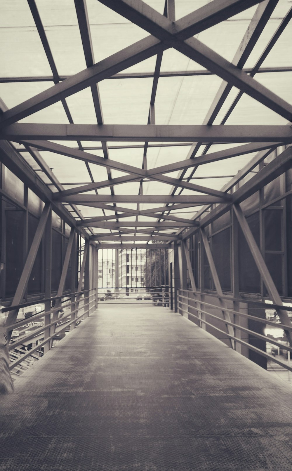 a long walkway with a metal roof and railings