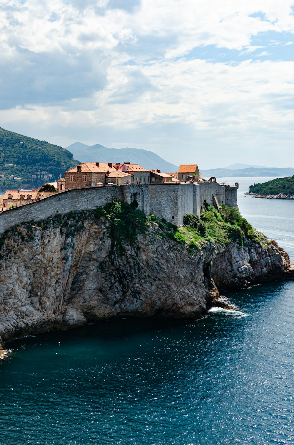 a castle on top of a rock in the middle of a body of water