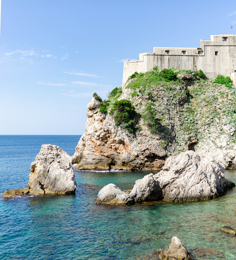 a castle sitting on top of a cliff next to the ocean