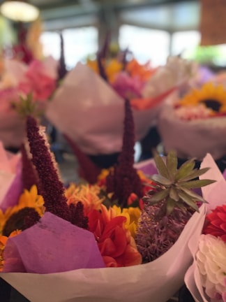 A close-up of a vibrant bouquet of mixed seasonal flowers in soft natural light