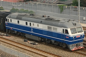 a blue and white train traveling down train tracks